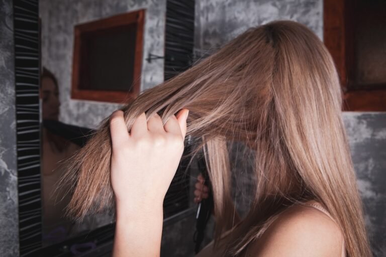 Mulher com cabelo cacheado, rotina de cuidados capilares no banheiro