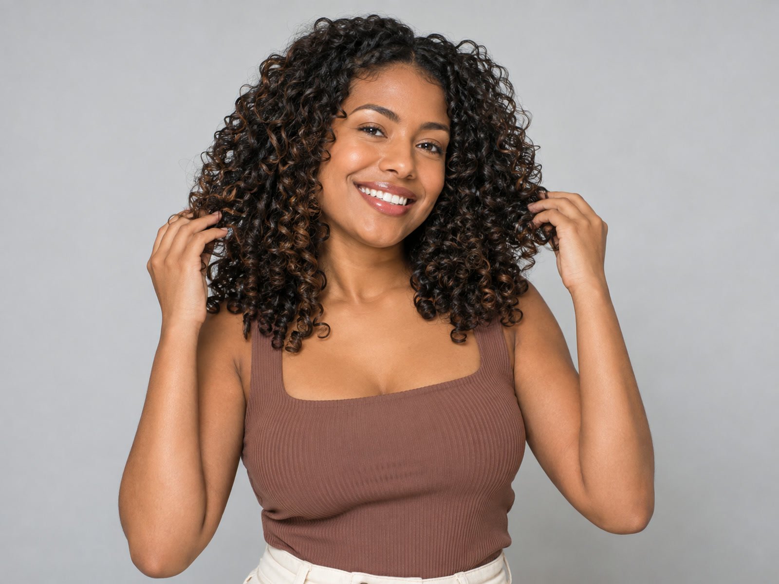 Mulher sorrindo com cabelo cacheado recém-lavado