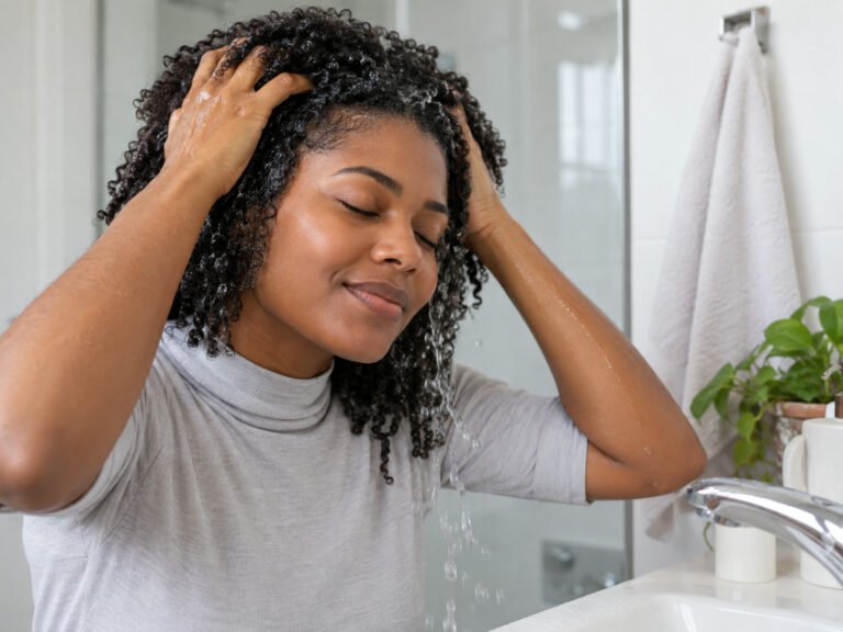 Mulher lavando o cabelo cacheado no método no-poo
