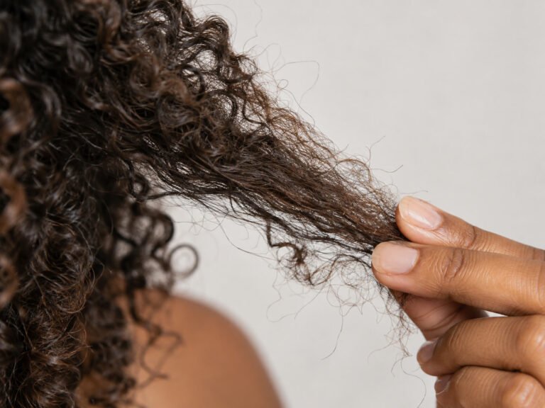 Close da ponta de um cabelo cacheado com sinais de ressecamento